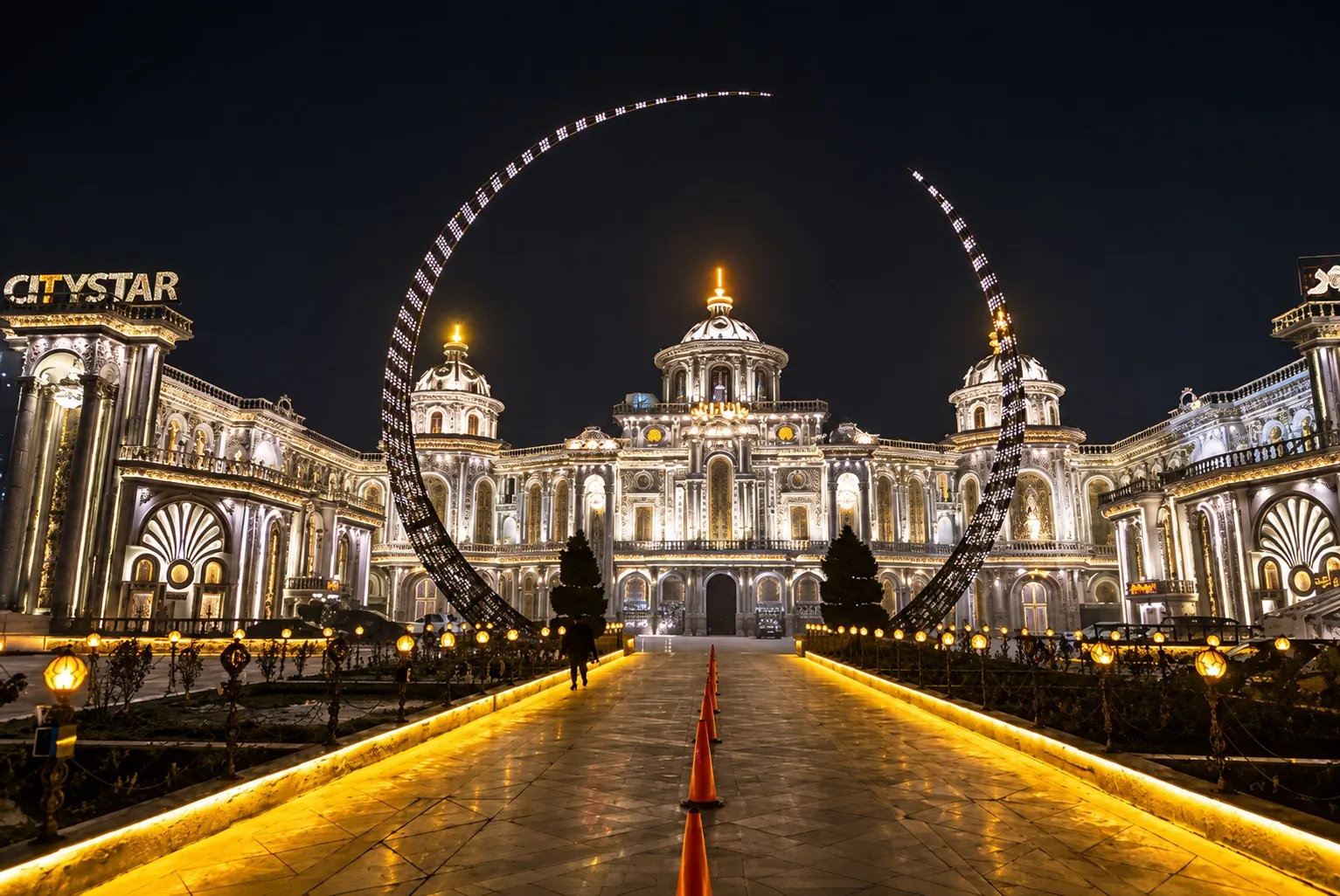 Illuminated wedding hall at night with a City Star sign and a lit archway entrance