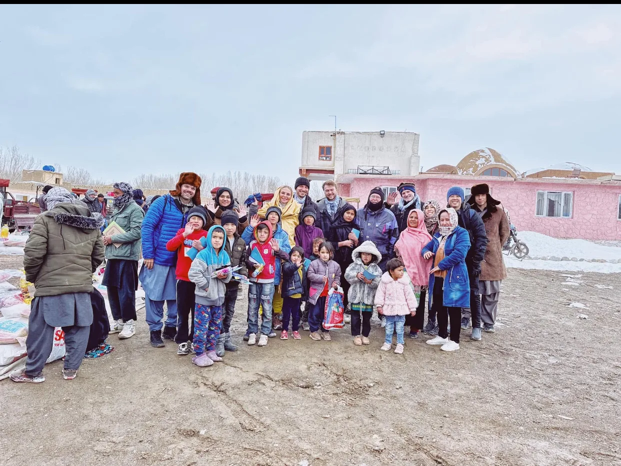 Travelers and local families during a winter visit in Bamyan